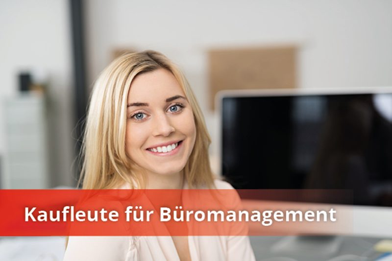 Auszubildende zur Kauffrau für Büromanagement arbeitet am Computer und lächelt – Einblick in den Ausbildungsalltag bei der Caritas.